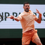 Djokovic chiede spazio a un cameraman durante il Roland Garros